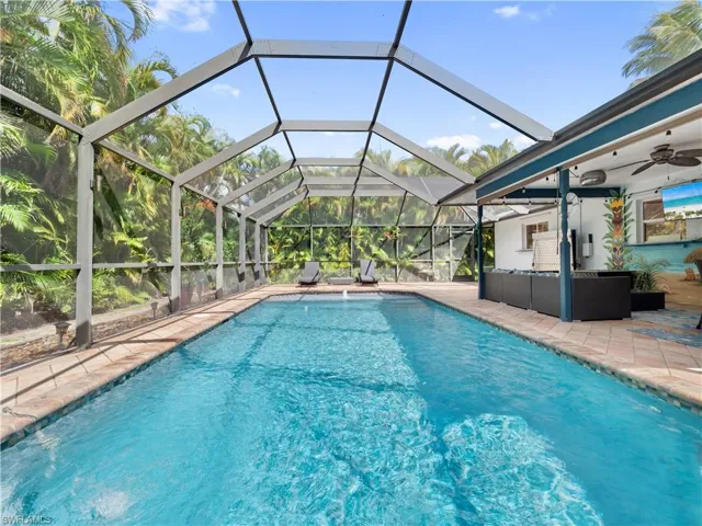 Outdoor pool featuring a sunroom, an outdoor hangout area, a lanai, and a patio area
