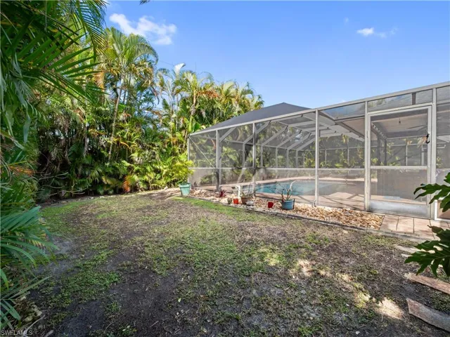 View of yard with an outdoor pool, a lanai, and a sunroom