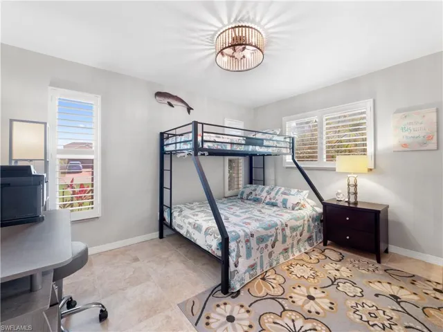 Bedroom with baseboards and an office area
