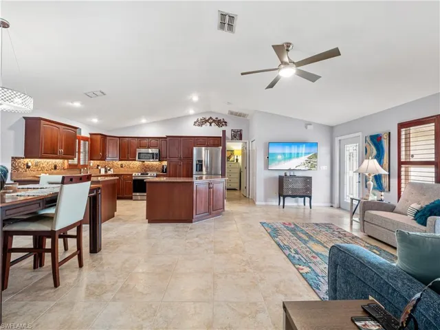Living room featuring a ceiling fan, healthy amount of natural light, and vaulted ceiling