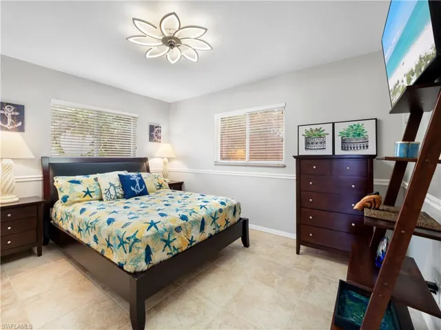 Bedroom with multiple windows and light tile patterned floors