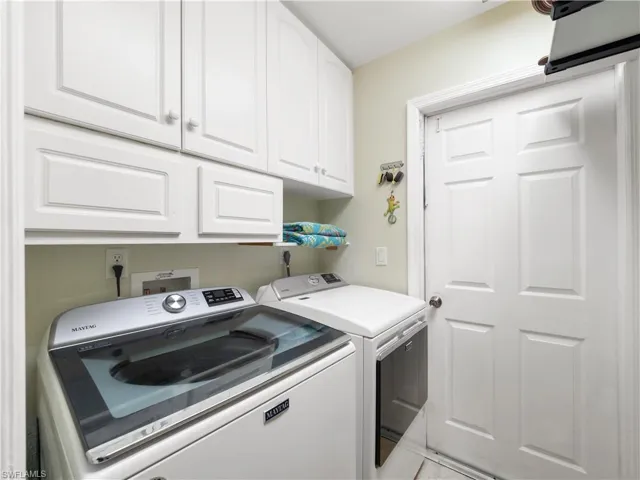 Laundry area with cabinet space and washing machine and clothes dryer