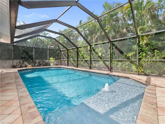 Outdoor pool with a lanai and a sunroom