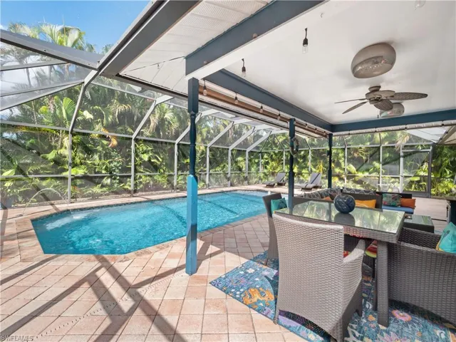 Outdoor pool with a sunroom, a lanai, a patio area, and outdoor dining area