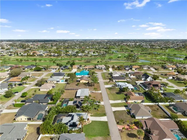 Aerial overview of property's location featuring a local golf course, nearby suburban area, and a nearby body of water