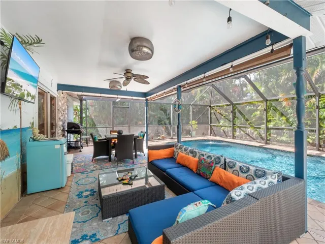 View of patio / terrace featuring a sunroom, an outdoor pool, a lanai, a ceiling fan, and an outdoor living / dining area