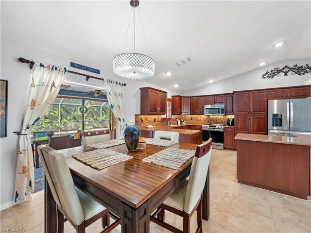Dining room with lofted ceiling, recessed lighting, and light tile patterned floors