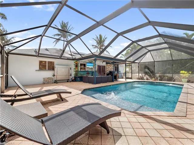 Outdoor pool with an outdoor lounge area, a lanai, a patio, and a sunroom
