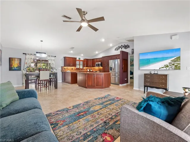 Living room featuring ceiling fan and lofted ceiling