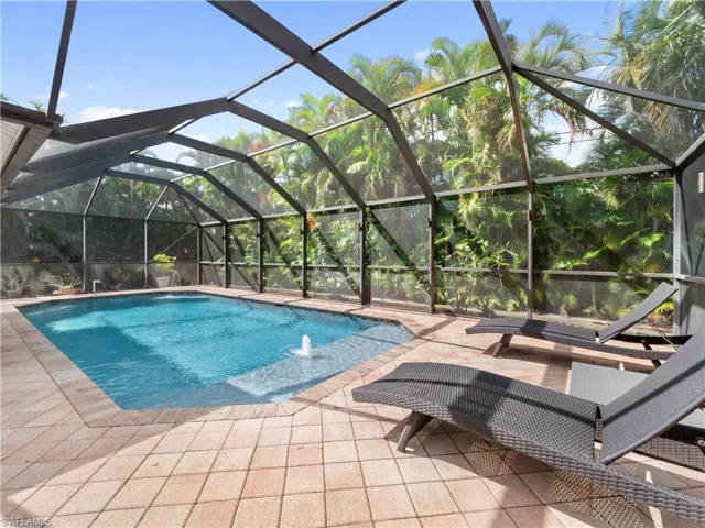 Swimming pool with a sunroom, glass enclosure, and a patio