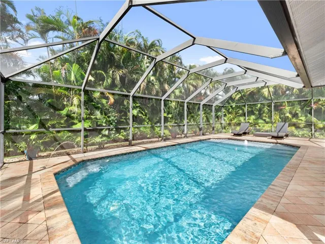 Swimming pool featuring a lanai, a sunroom, and a patio area