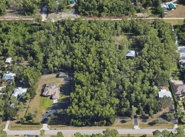 Aerial view of property and surrounding area with a heavily wooded area