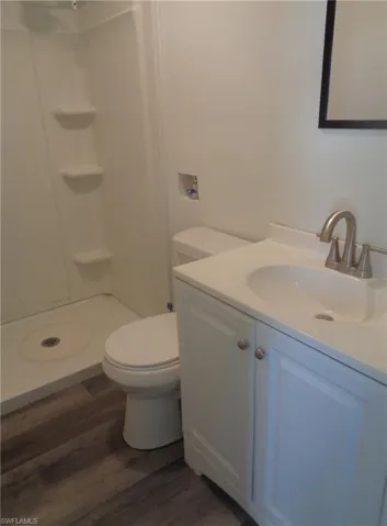 Bathroom of permitted 2 bed / 1 bath apartment with vanity, wood finished floors, and a shower