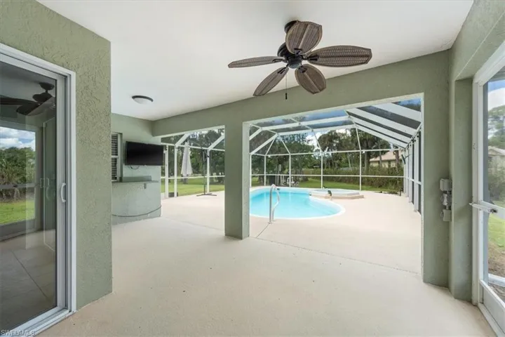 Outdoor pool featuring a patio, a sunroom, a ceiling fan, and a lanai
