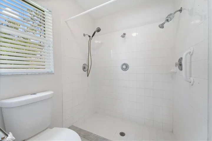 Bathroom with a shower stall and toilet