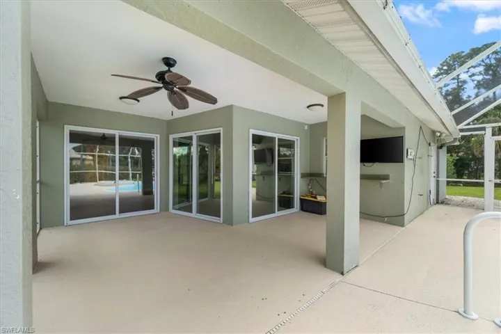 View of patio featuring glass enclosure and ceiling fan