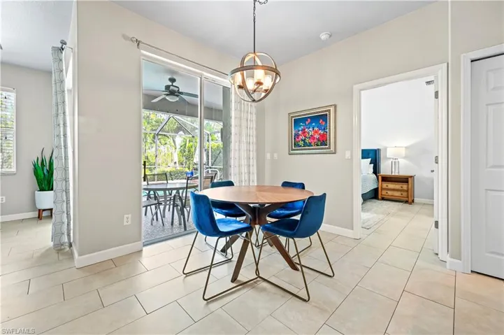 Tiled dining space featuring ceiling fan with notable chandelier and a wealth of natural light