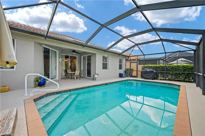 View of swimming pool featuring a patio area, a lanai