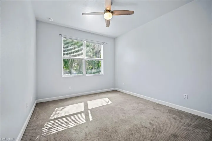 Empty room featuring carpet floors and ceiling fan