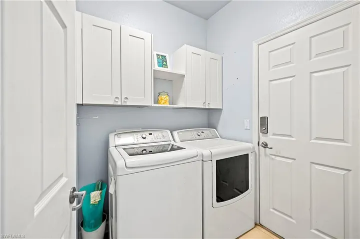 Clothes washing area with washer and dryer and cabinets