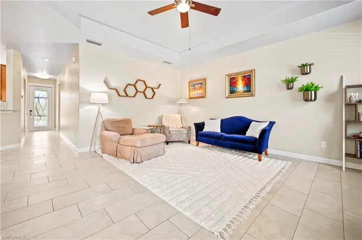 Living room featuring ceiling fan and light tile floors