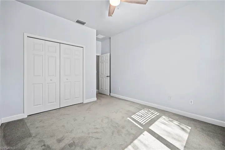Unfurnished bedroom featuring a closet, ceiling fan, and carpet floors