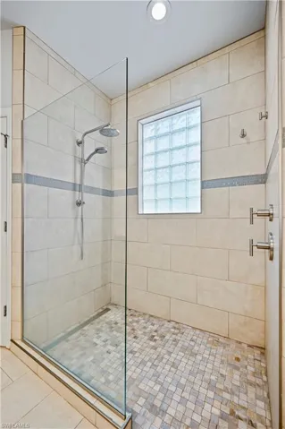 Bathroom with a shower with shower door and tile floors