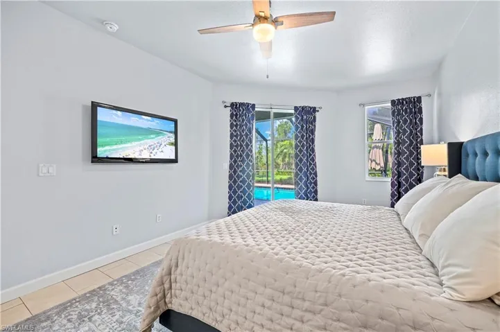 Tiled bedroom featuring access to outside and ceiling fan
