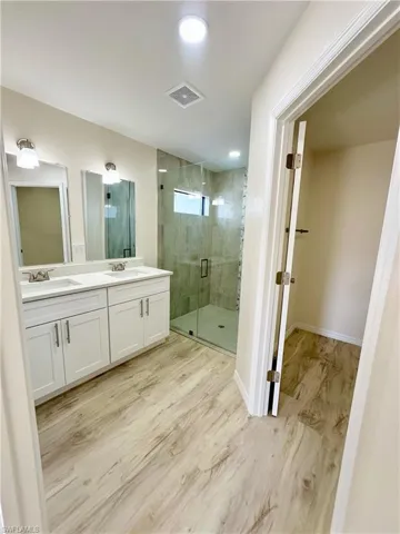 Bathroom featuring vanity and a shower with shower door