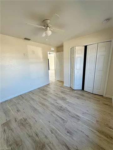 Unfurnished bedroom with ceiling fan, light hardwood / wood-style floors, and a closet