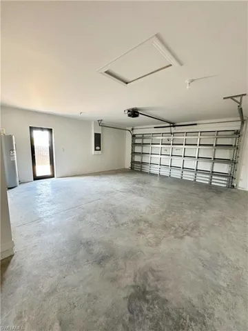 Garage featuring electric panel, water heater, and a garage door opener