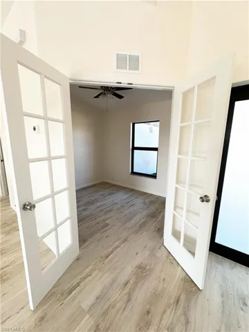 Spare room featuring ceiling fan, light wood-type flooring, and french doors