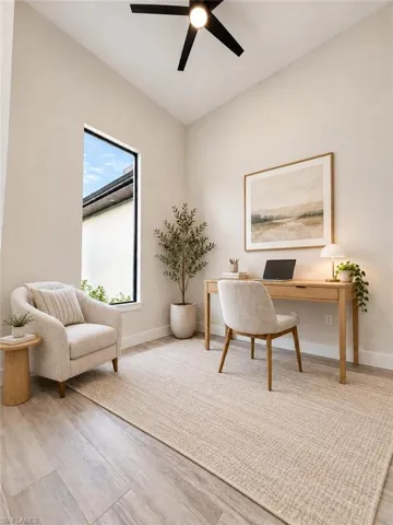 Vaulted ceiling with a black ceiling fan, wood-finish flooring, and a large vertical window