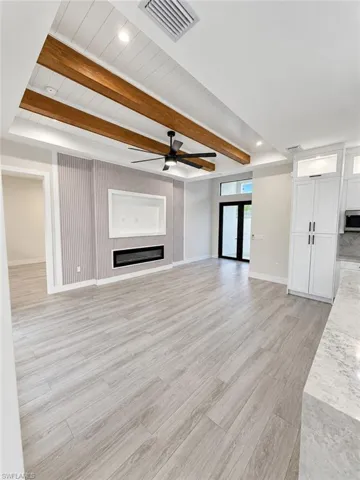 Tray ceiling with wood-finish beams and recessed lighting