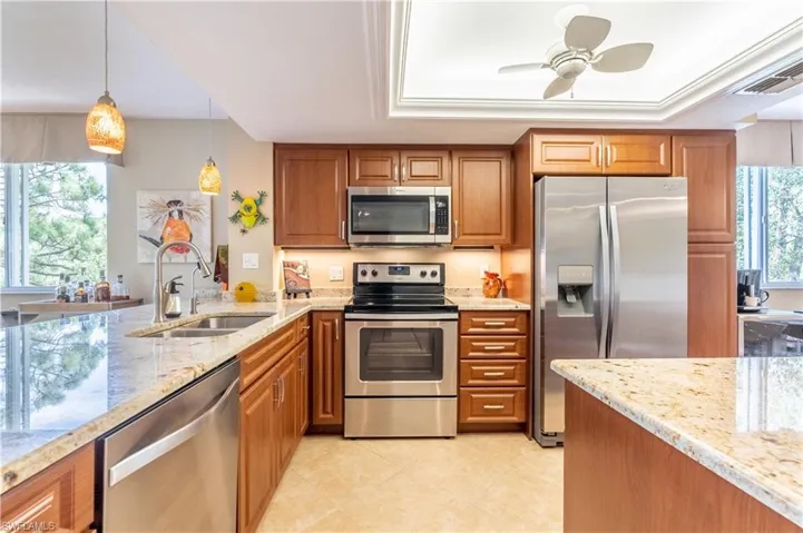Kitchen featuring raised panel cabinets, stainless steel appliances, and light countertops