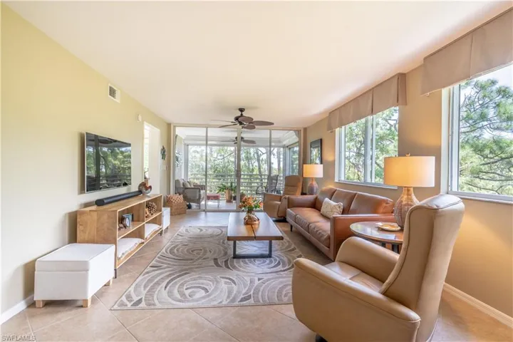Tiled living room brightened by large windows