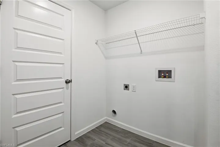 Laundry area with hookup for an electric dryer, hookup for a washing machine, and dark wood finished floors