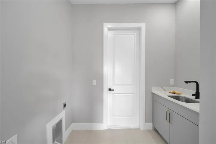 Washroom with electric dryer hookup and cabinet space
