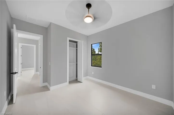 Unfurnished bedroom featuring baseboards and ceiling fan