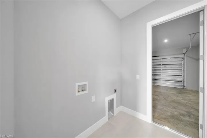 Washroom featuring electric dryer hookup, finished concrete flooring, and washer hookup