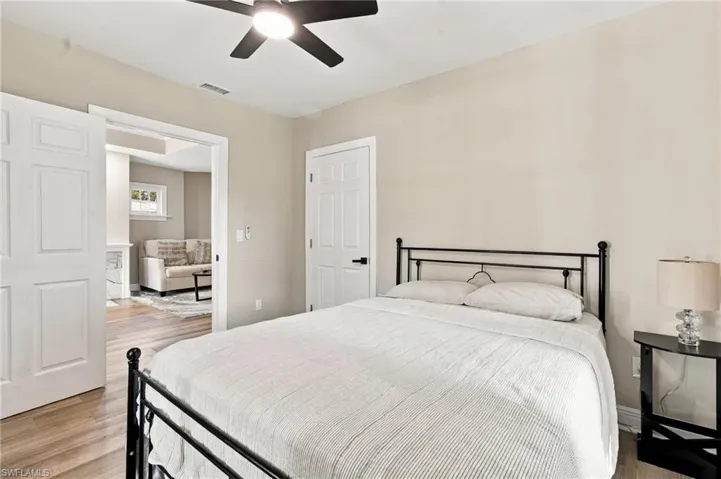 3rd bedroom with wood-plank tile flooring, white trim, a ceiling fan with integrated lighting, and multiple windows.