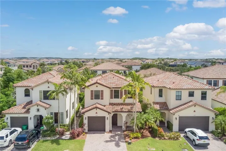 Mediterranean / spanish-style home with stucco siding, a residential view, a tiled roof, and decorative driveway