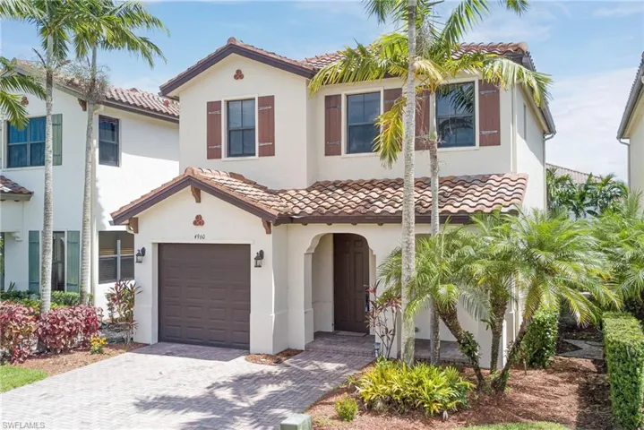 Mediterranean / spanish house featuring a garage, decorative driveway, stucco siding, and a tile roof