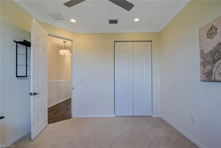 Unfurnished bedroom featuring carpet flooring, crown molding, recessed lighting, a closet, and a ceiling fan