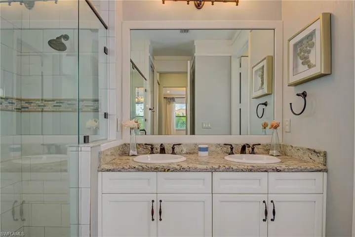 Full bath featuring a stall shower and double vanity