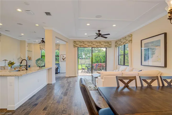 Dining area featuring ornamental molding, dark wood-type flooring, recessed lighting, and a ceiling fan