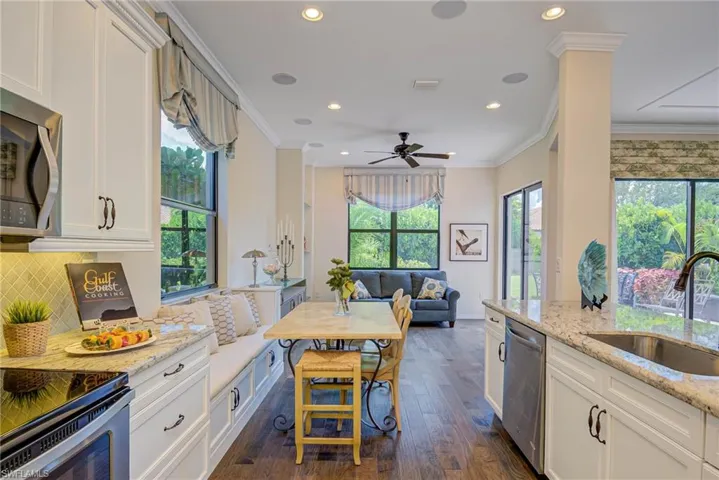 Kitchen featuring crown molding, recessed lighting, dark wood finished floors, open floor plan, and white cabinetry