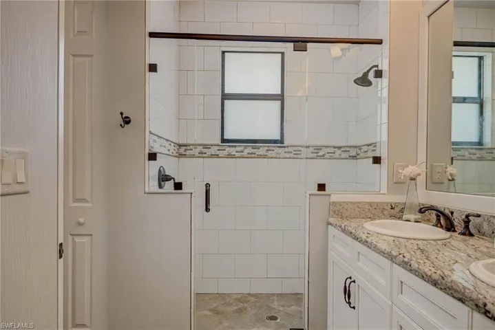 Full bath featuring a stall shower and double vanity