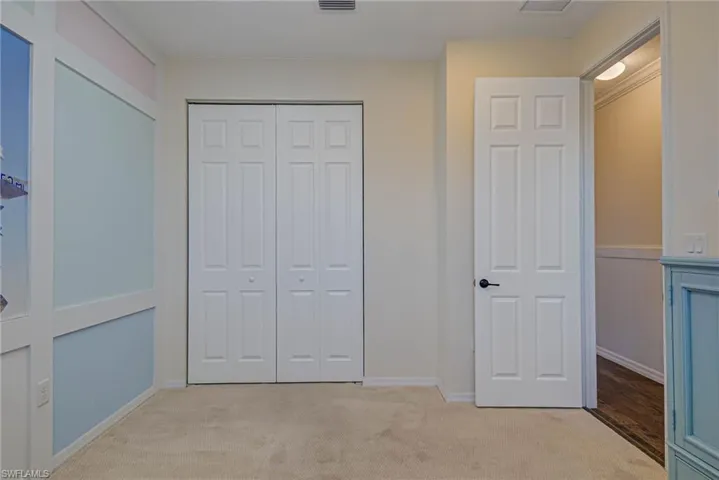 Unfurnished bedroom featuring a closet and light carpet