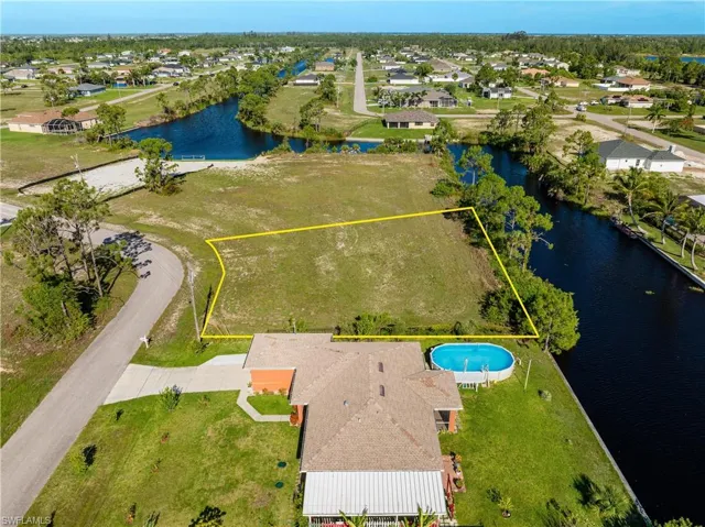 Aerial view of residential area featuring a nearby body of water and property boundaries highlighted